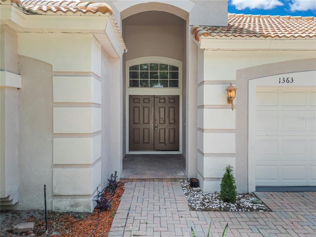 The exterior view shows a house entrance with a double door, arched transom, and garage — 1363 GLENWICK DRIVE, WINDERMERE, FL