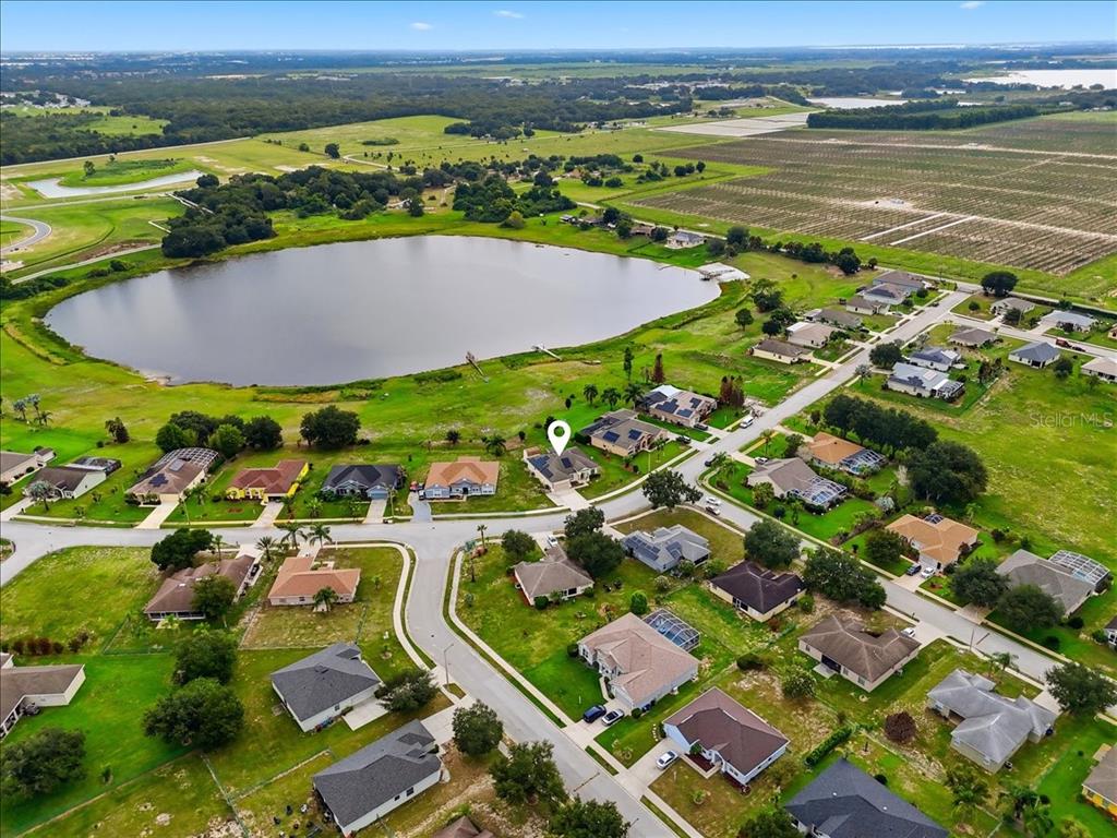 An aerial view shows a suburban neighborhood with houses surrounding a large lake — 4387 DINNER LAKE BOULEVARD, LAKE WALES, FL