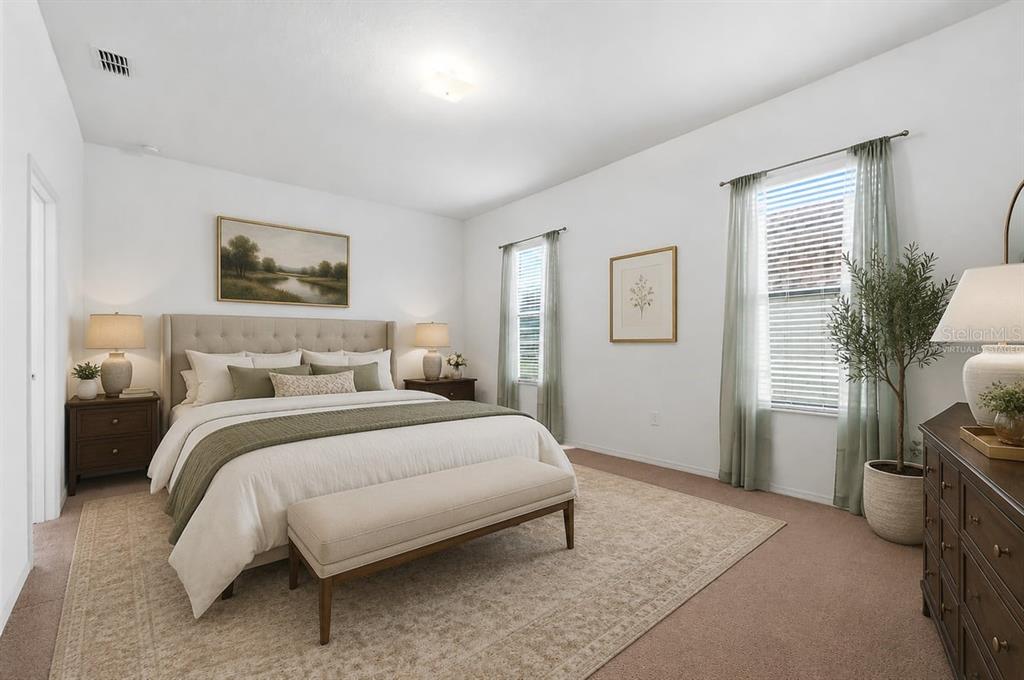 A bedroom features a king-sized bed, a bench, two nightstands, and two windows with curtains — 4387 DINNER LAKE BOULEVARD, LAKE WALES, FL
