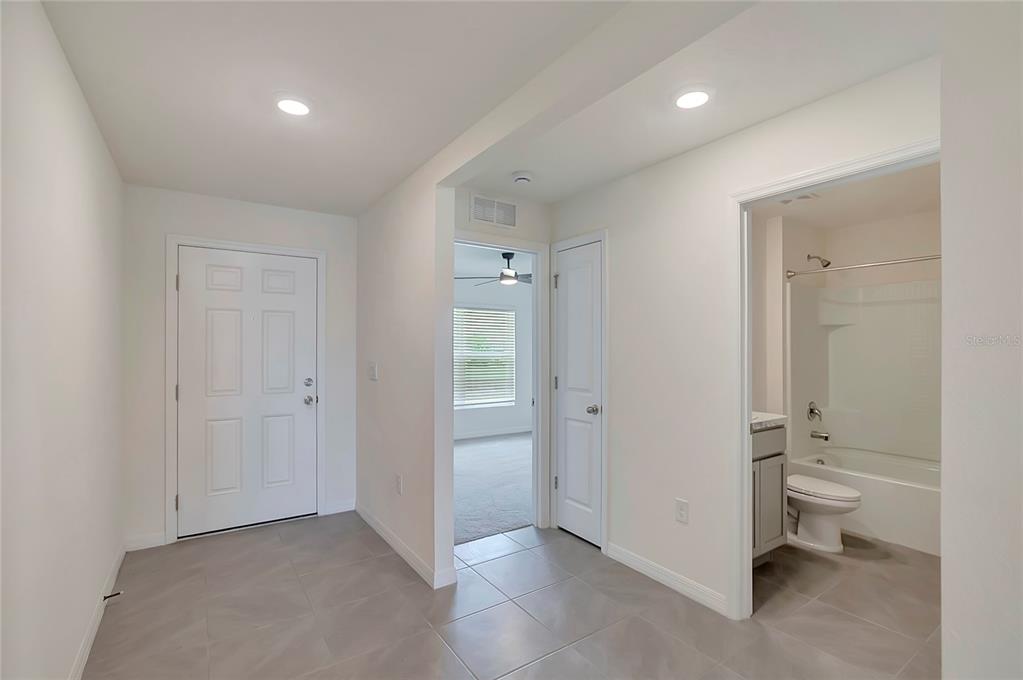 A tiled entryway leads to a bathroom, a closet, and a carpeted bedroom — 810 ACE OUTLAW AVENUE, RUSKIN, FL