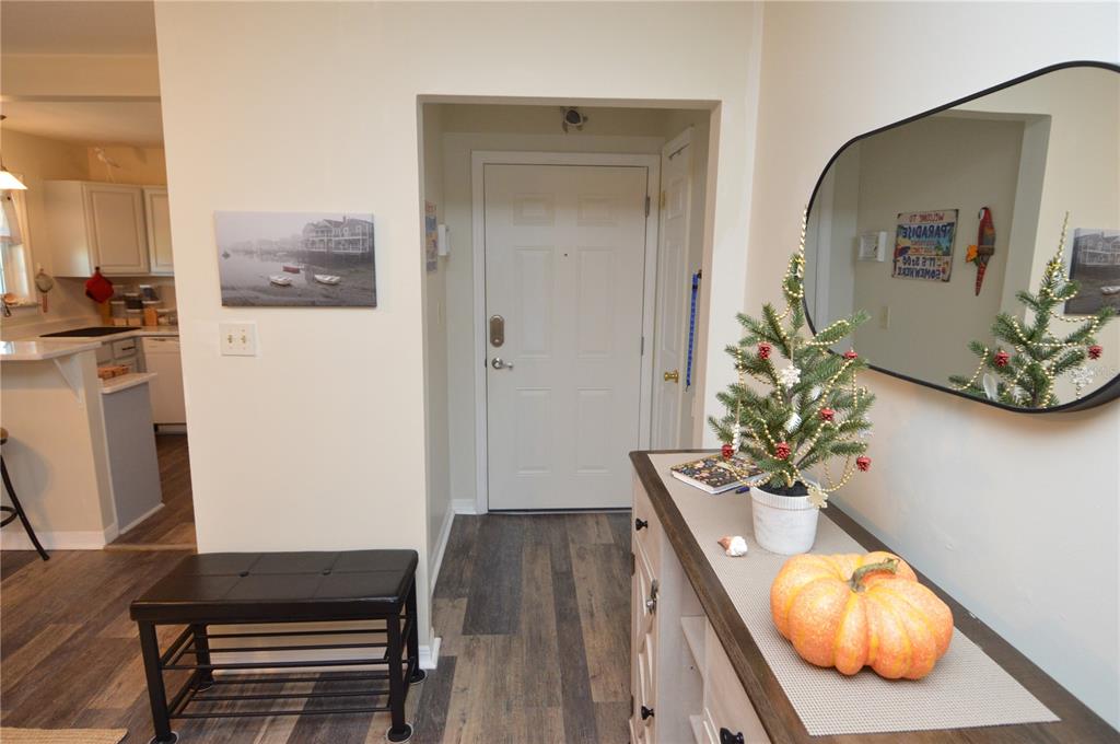 An entryway features wood-look flooring, a white front door, a console table, and a mirror — 121 SEAHORSE DRIVE SE UNIT C, ST PETERSBURG, FL