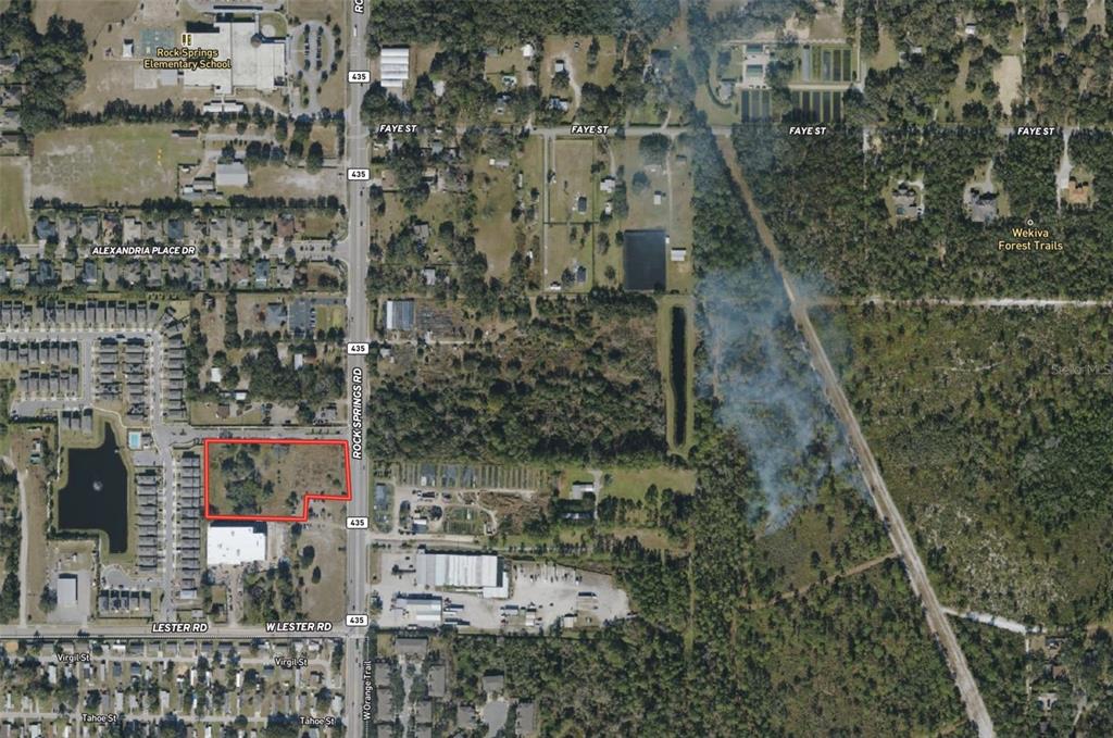 A vacant, grassy lot sits alongside a paved road with a car driving past — 2104 ROCK SPRINGS ROAD, APOPKA, FL