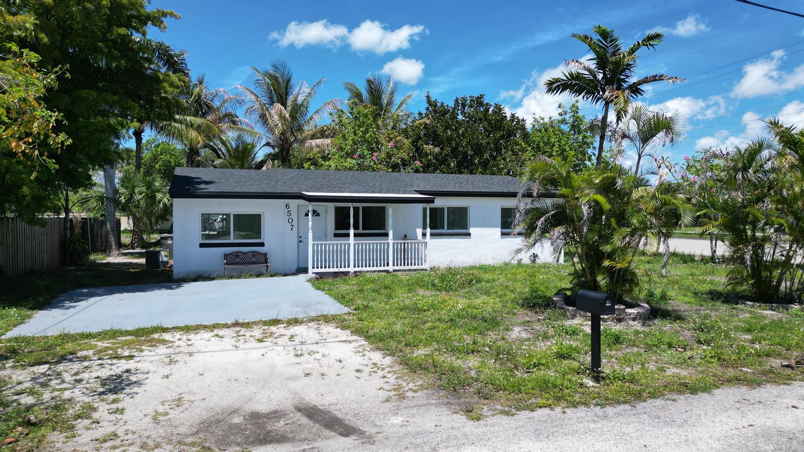 A single-story white house with a porch, a paved driveway, and palm trees — 6507 Alexander Road, West Palm Beach FL 33413, WEST PALM BEACH, FL
