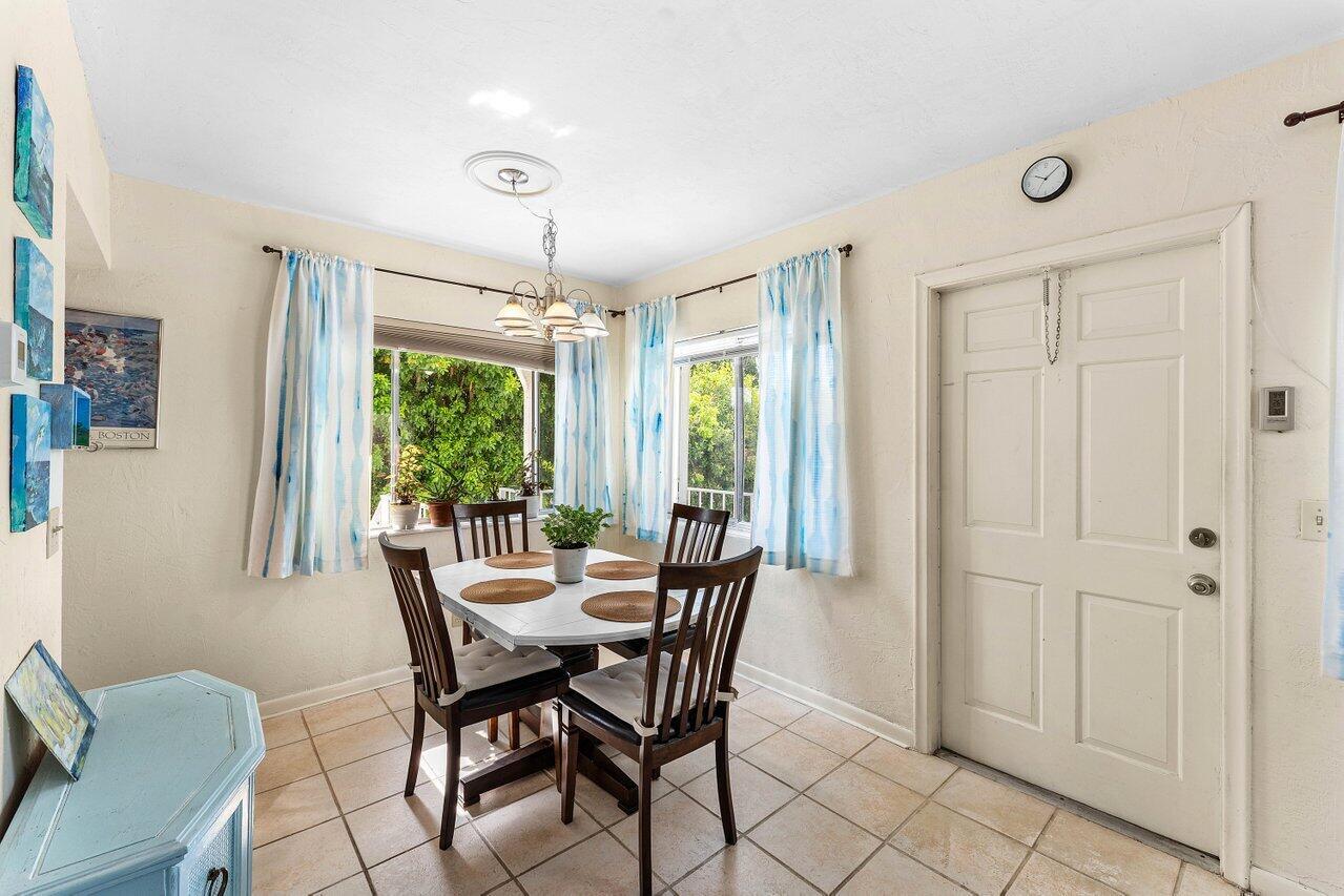 A dining area features a white table with four chairs, tiled floors, and two windows — 3280 Cynthia Lane # 214, FL 33461, FL