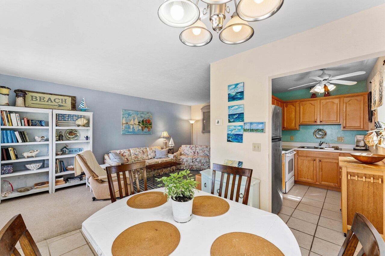 A dining area in the foreground opens into a living room and a kitchen — 3280 Cynthia Lane # 214, FL 33461, FL