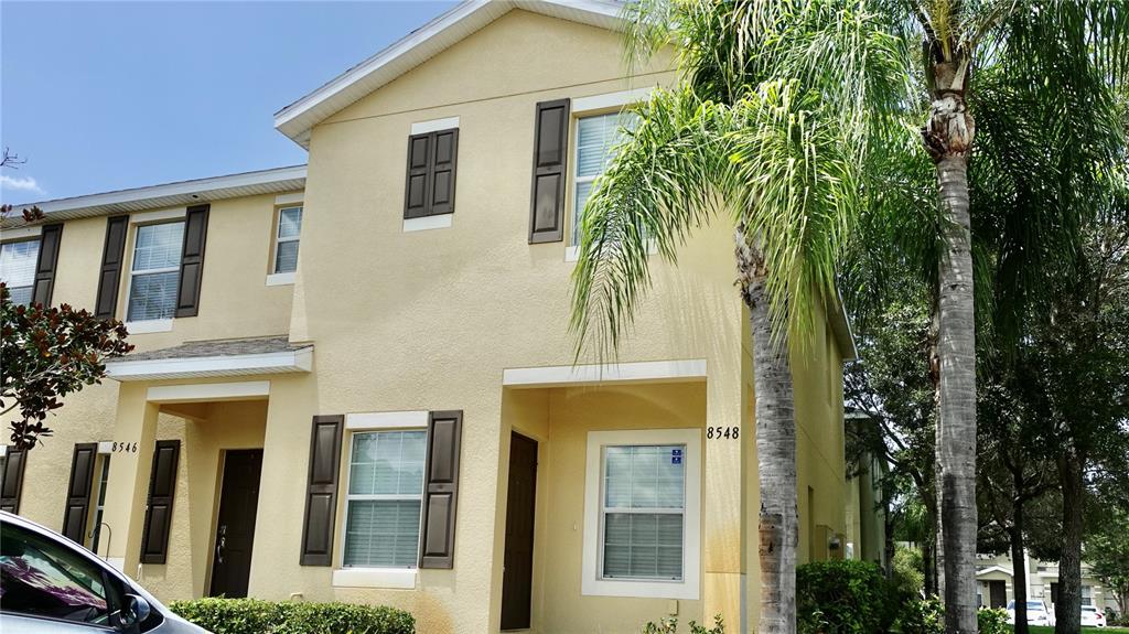 A two-story yellow townhouse with brown shutters and a palm tree in the front yard — 8548 GABLEBEND WAY, TAMPA, FL