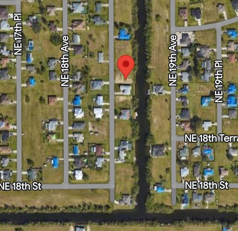 This is a satellite map view showing a vacant residential lot marked with a pin — 1905 NE 18TH PLACE, CAPE CORAL, FL