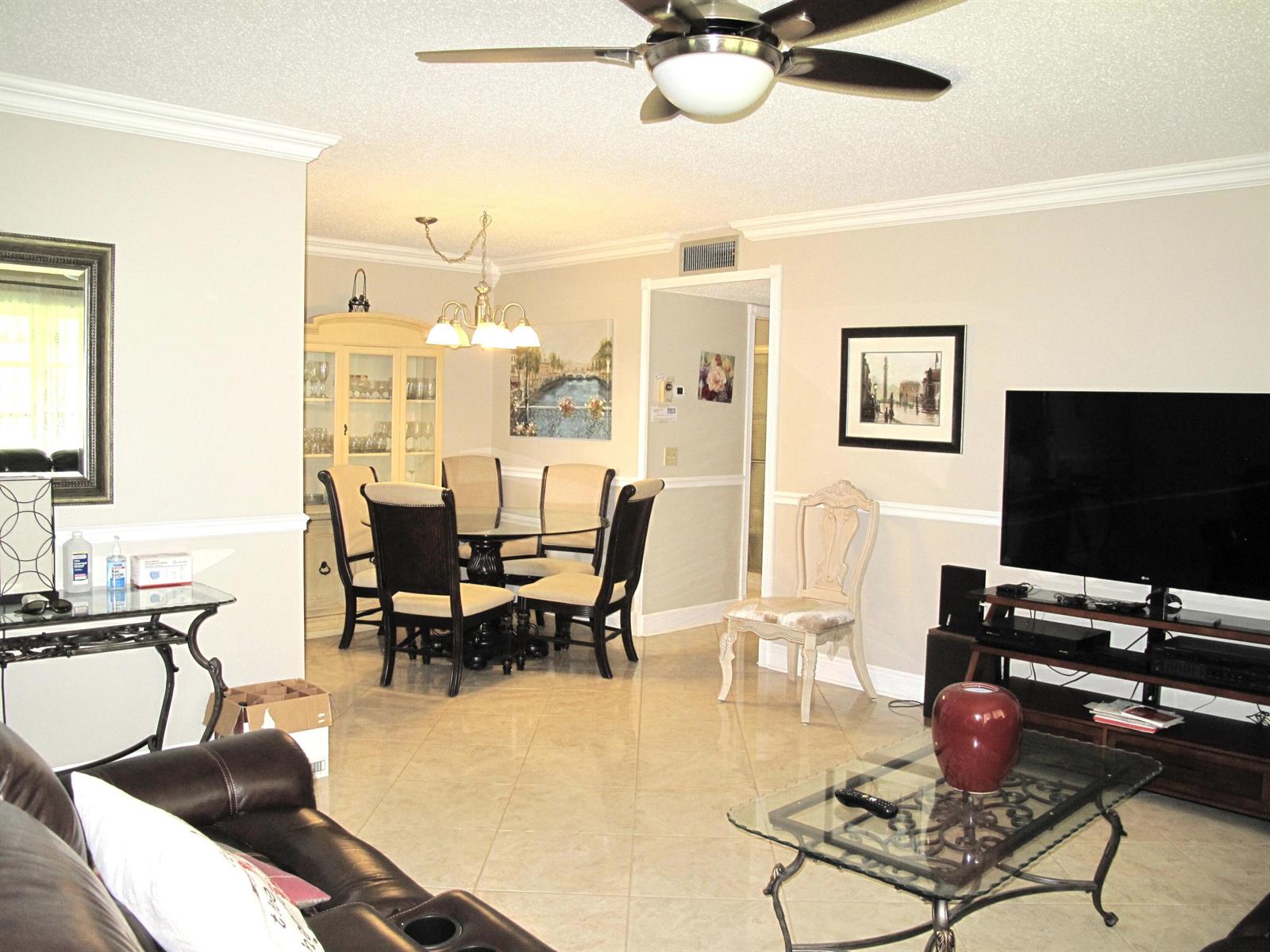 A living room and dining area with tile floors, a ceiling fan, and neutral walls — 892 N High Point Boulevard N # D, Delray Beach FL 33445, DELRAY BEACH, FL