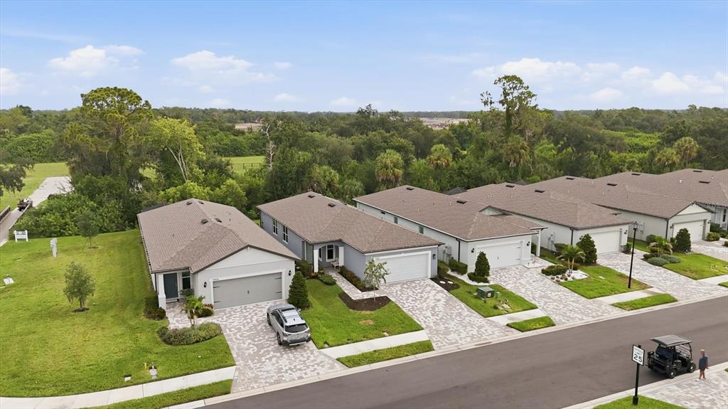 An aerial view shows a row of modern single-story houses with paved driveways and lawns — 9410 SHOREBIRD COURT, PARRISH, FL