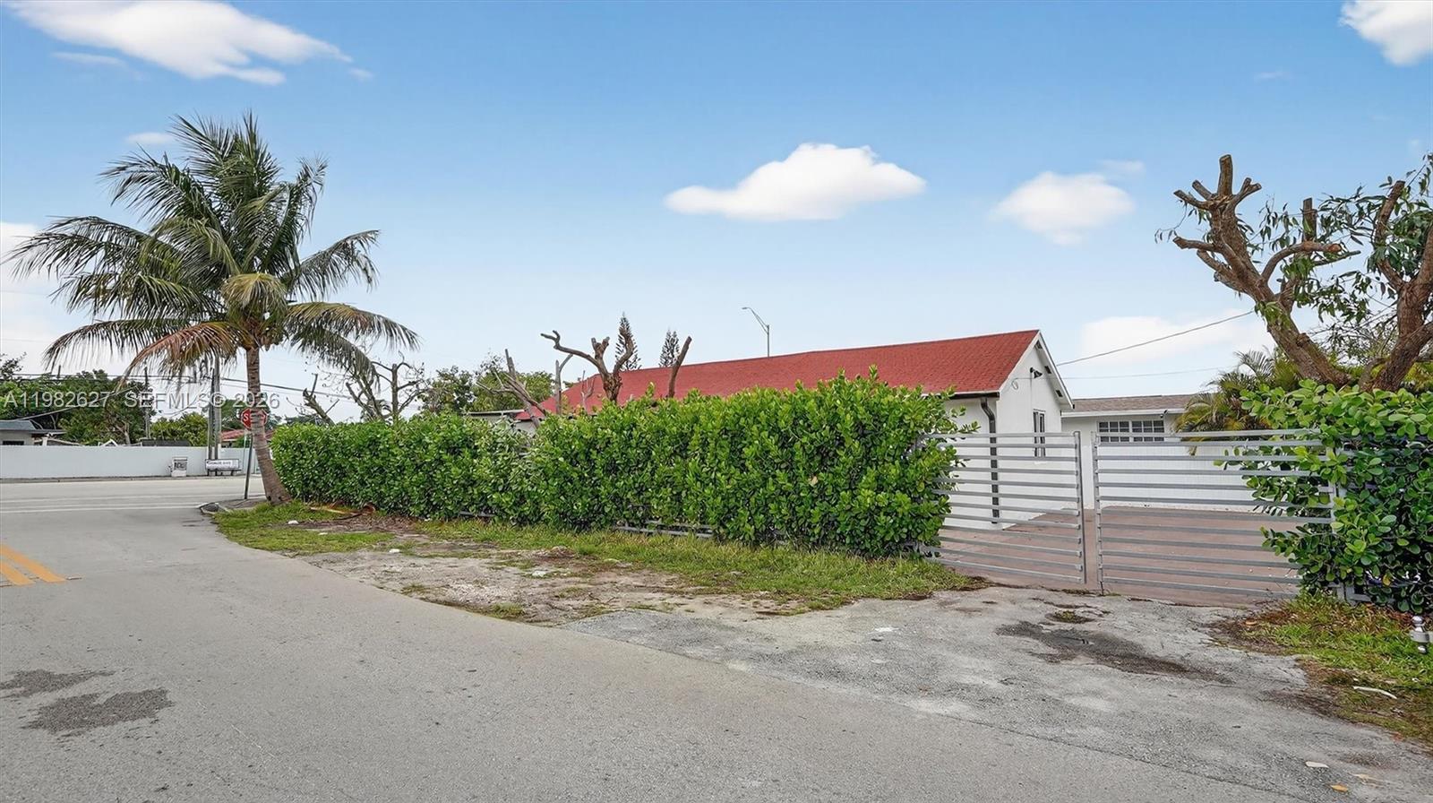 A single-story house with a red roof stands behind a hedge and metal gate — 2845 SW 67th Ave, Miami FL 33155, MIAMI, FL