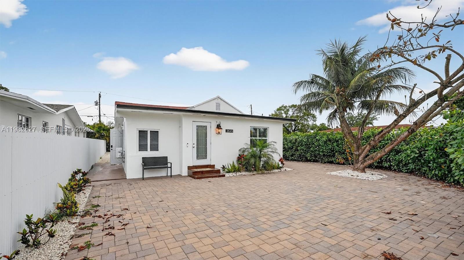 A white single-story house features a paved driveway, a palm tree, and a white fence — 2845 SW 67th Ave, Miami FL 33155, MIAMI, FL