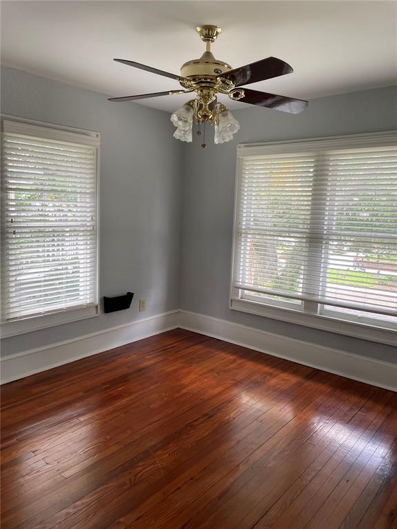 An empty room with hardwood floors, light blue walls, two windows with blinds, and a fan — 612 E CENTRAL BOULEVARD, ORLANDO, FL