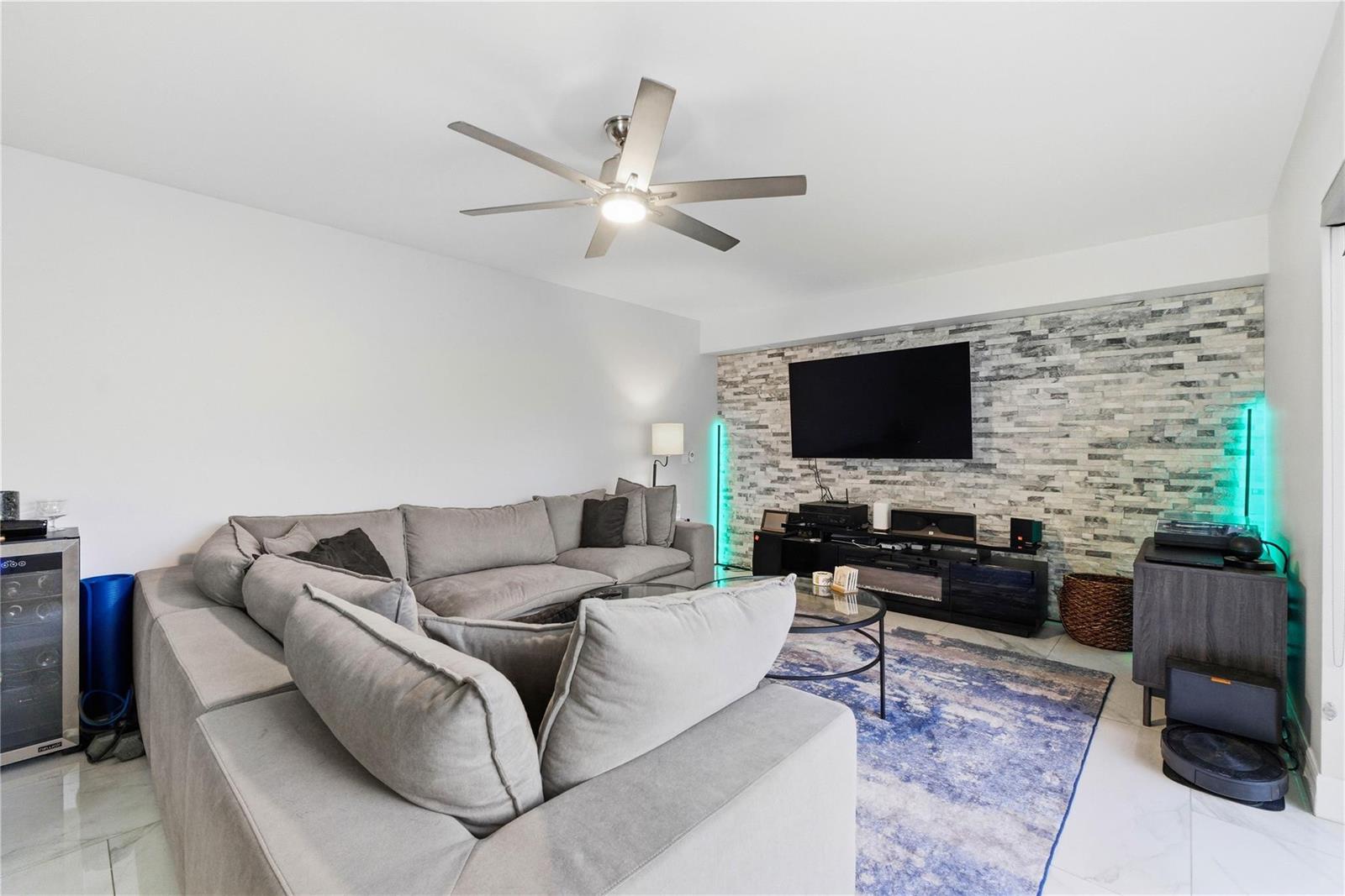 A living room features a gray sectional sofa, a stone accent wall, and a ceiling fan — 1017 10th Way, West Palm Beach FL 33407, WEST PALM BEACH, FL