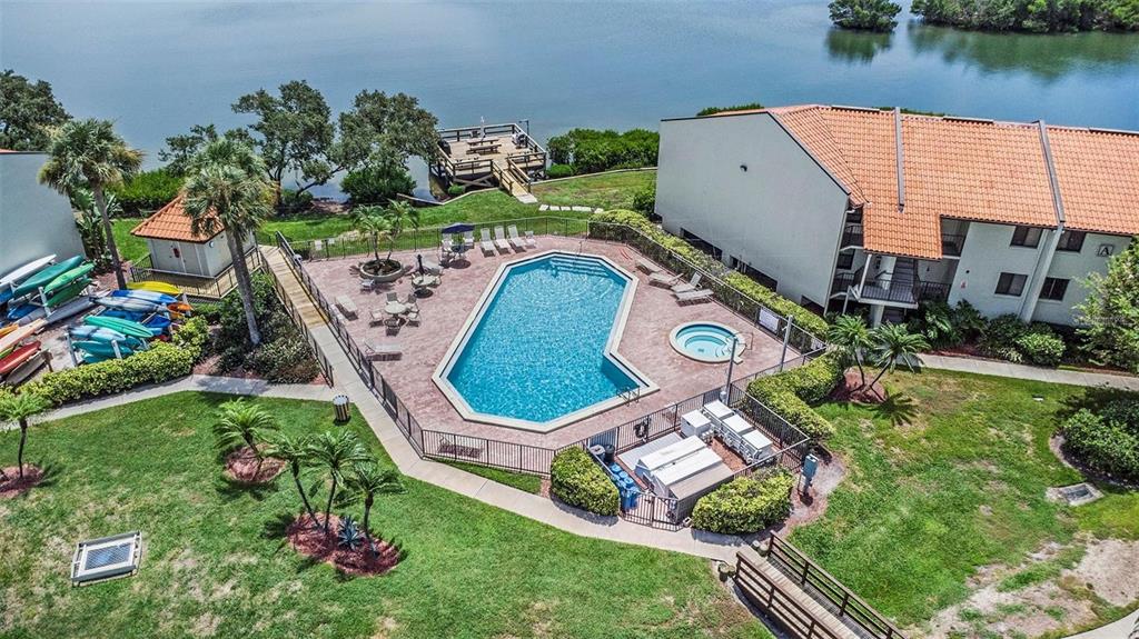An aerial view shows a swimming pool and hot tub surrounded by a fenced patio — 1515 PINELLAS BAYWAY S UNIT 26, ST PETERSBURG, FL