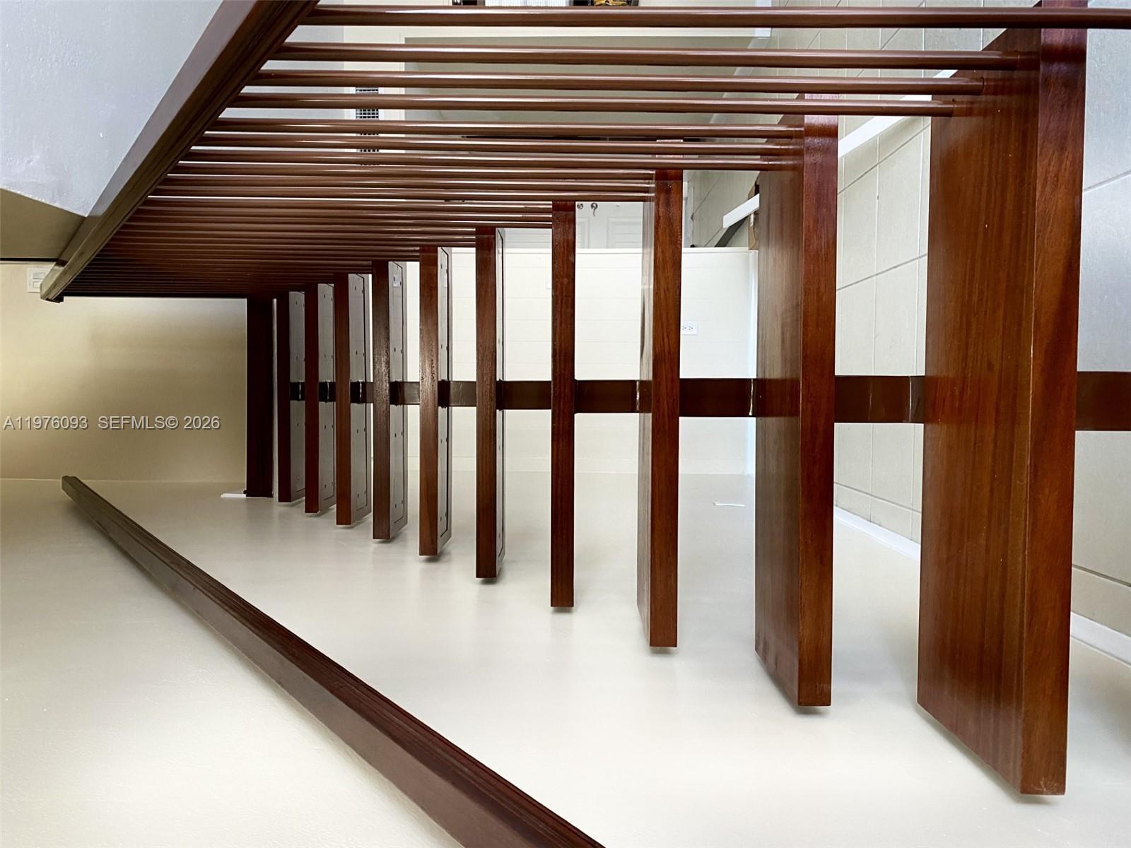 A low-angle view shows a wooden staircase with vertical slats and a horizontal support beam — 2183 NE 122nd St # 2183, North Miami FL 33181, NORTH MIAMI, FL