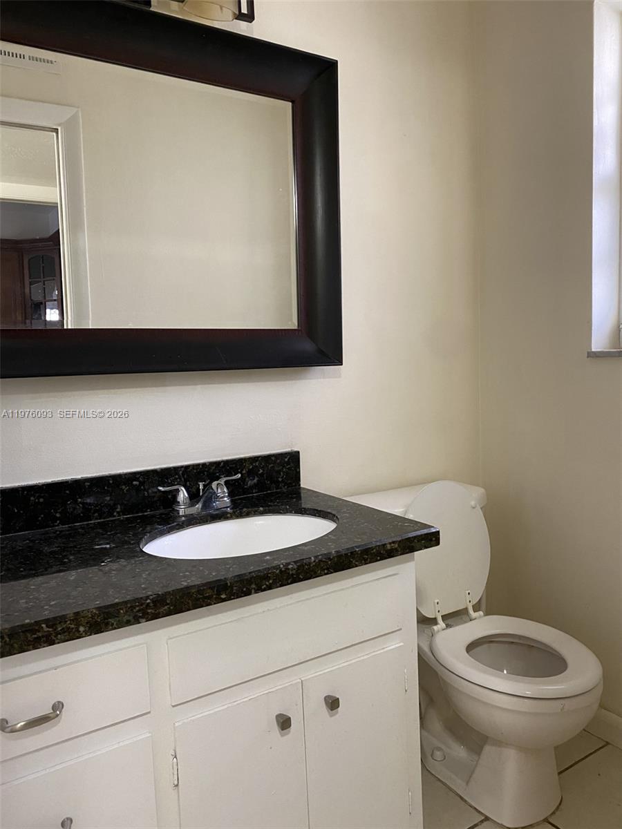 A bathroom features a white vanity with a dark granite countertop and a large mirror — 2183 NE 122nd St # 2183, North Miami FL 33181, NORTH MIAMI, FL