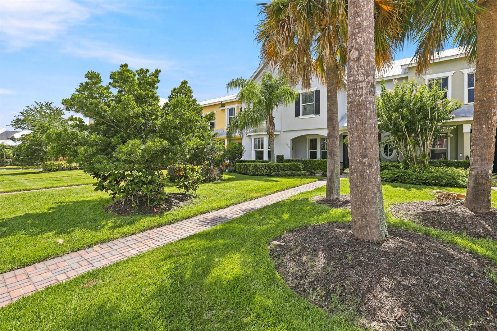 A brick walkway leads to the front entrance of a two-story house with landscaping — 10487 SW West Park Avenue, FL 34987, FL