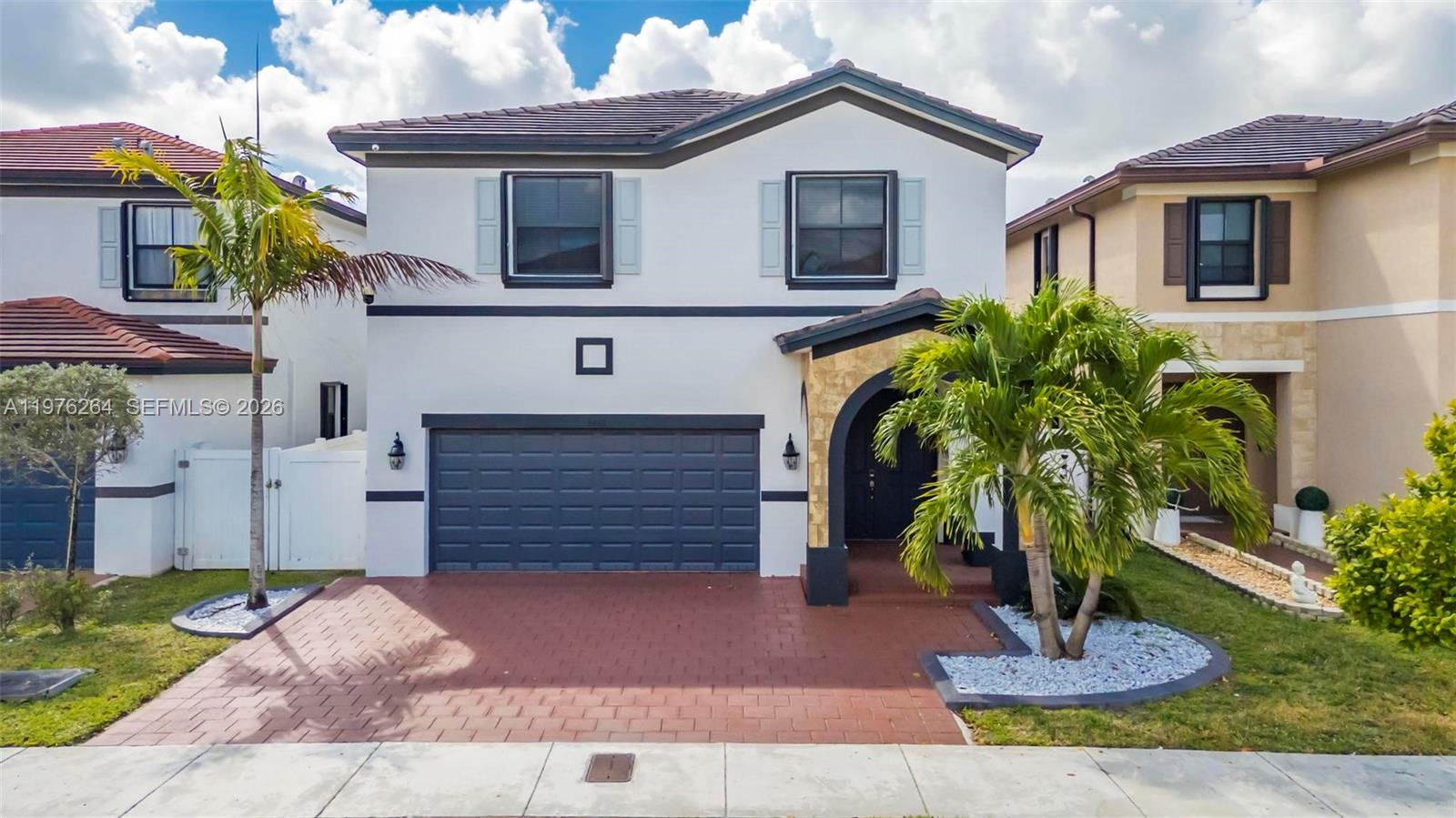 A two-story house features a white stucco exterior, a dark garage, and a paved driveway — 3440 W 100th Ter, Hialeah FL 33018, HIALEAH, FL