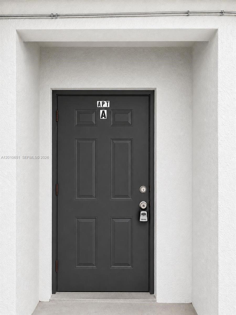 A dark gray door labeled Apt A is set within a white recessed entryway — 8180 NW 23rd Ave # A, Miami FL 33147, MIAMI, FL