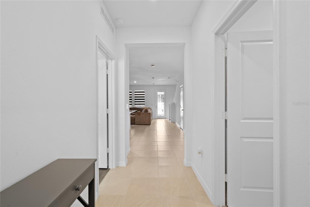 A bright hallway with light tile flooring leads to an open living area — 655 CLARK STREET, OVIEDO, FL