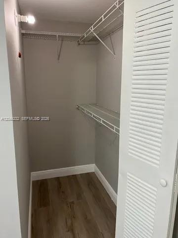 A walk-in closet with wire shelving, light gray walls, and wood-look flooring — 777 SW 9th Ave # 414, Miami FL 33130, MIAMI, FL