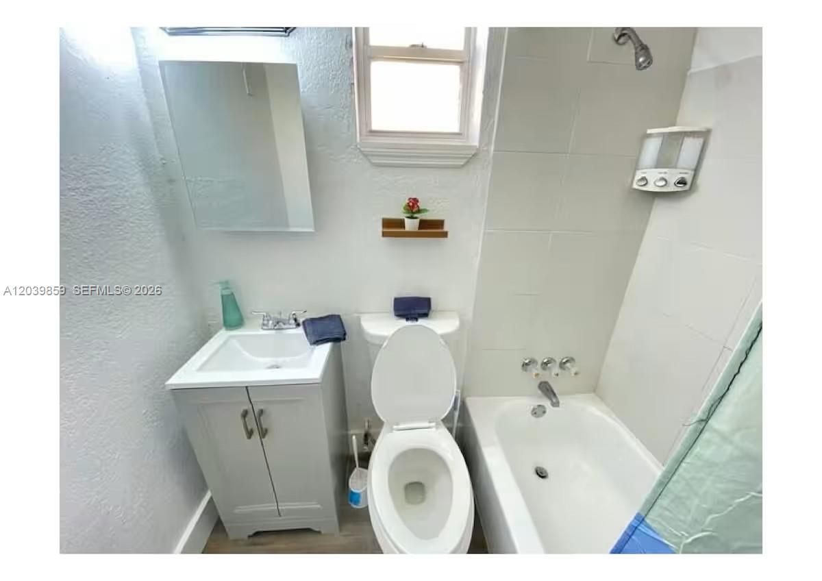 A small bathroom features a white vanity, a toilet, and a shower-tub combination — 7638 N Miami Ave # 2, Miami FL 33150, MIAMI, FL
