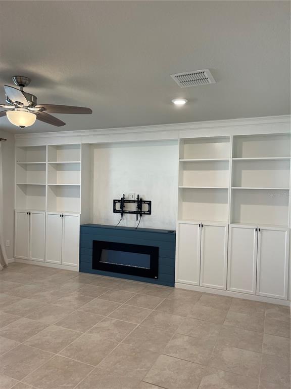 A living room features white built-in shelving flanking a blue fireplace with a wall-mounted TV bracket — 5503 KEATON SPRINGS DRIVE, LAKELAND, FL
