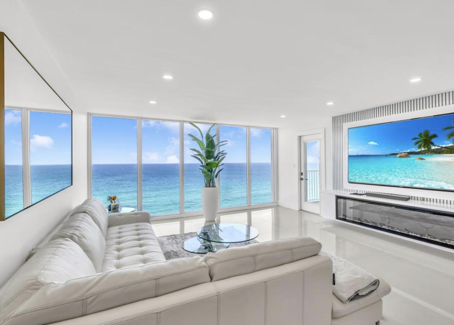 A modern living room features a white sectional sofa, glass coffee tables, and ocean views — 3000 S Ocean Boulevard # 1405, Boca Raton FL 33432, BOCA RATON, FL