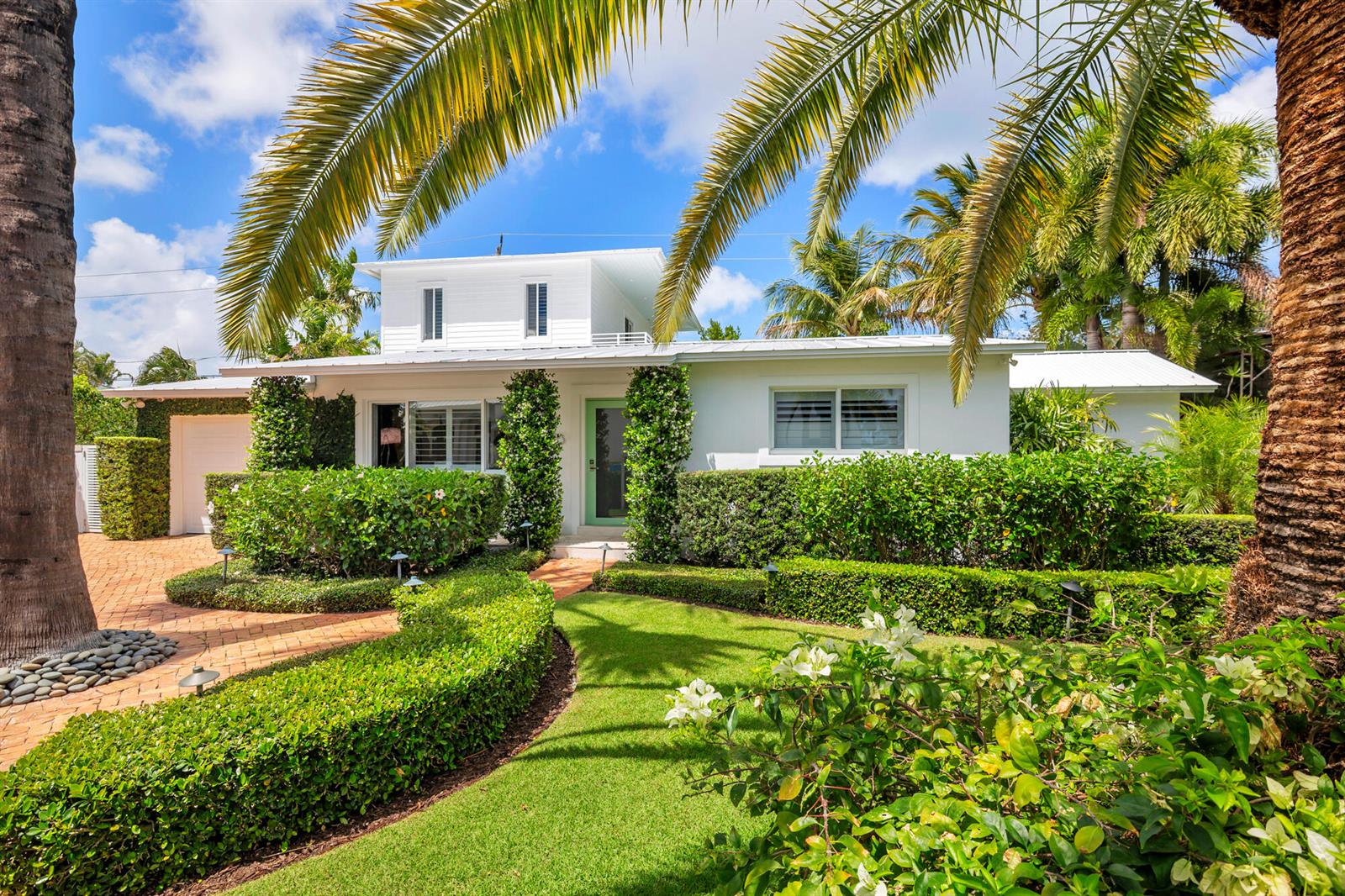 A white house with a green door, palm trees, and manicured hedges in the front yard — 203 Arlington Road, West Palm Beach FL 33405, WEST PALM BEACH, FL