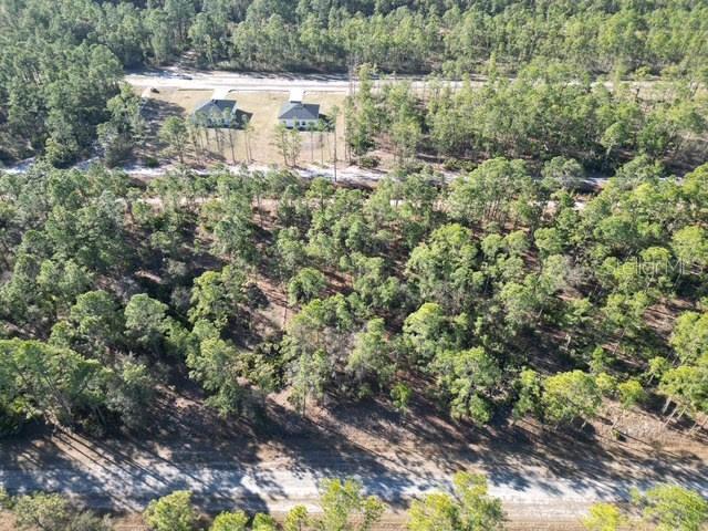 An aerial view shows a wooded lot with two houses in the background — 707 LAGUNA DRIVE, INDIAN LAKE ESTATES, FL