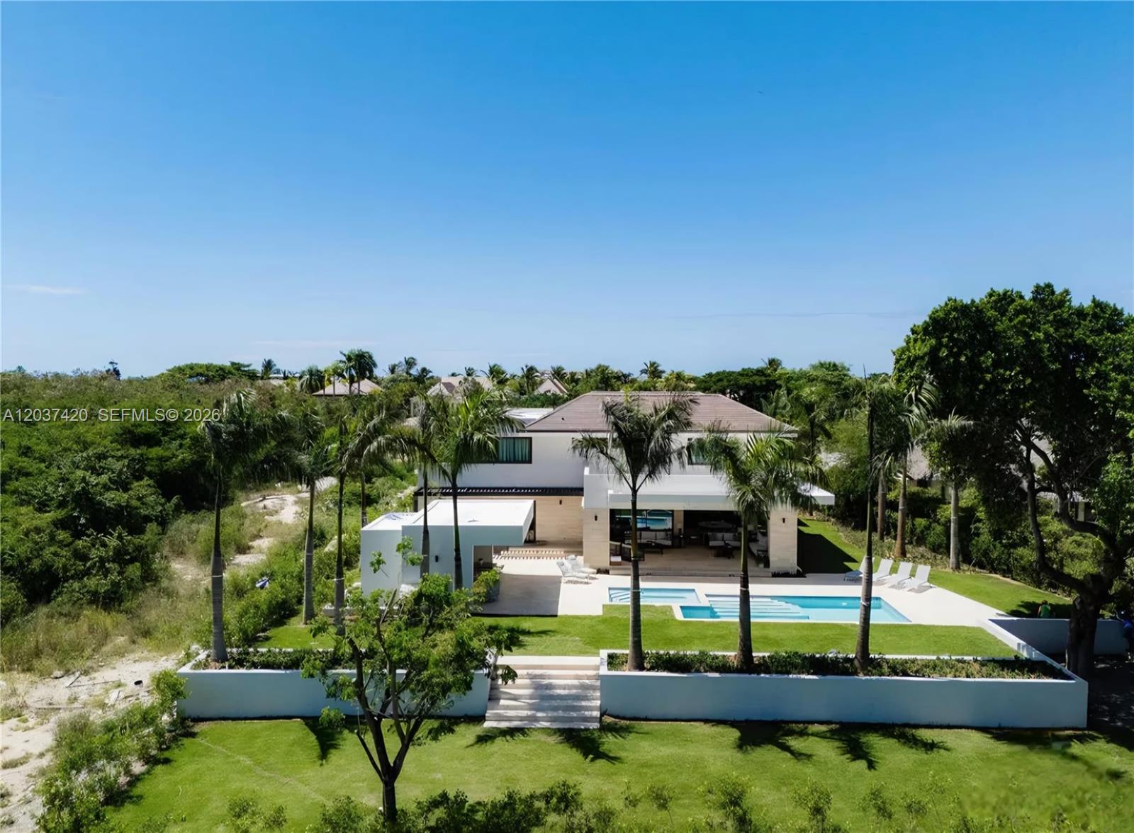 An aerial view of a modern two-story house with a swimming pool and palm trees — 0 Cana, FL