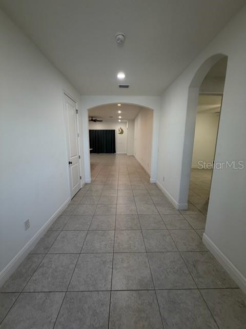 A tiled hallway leads toward an arched opening with a view into a living area — 3918 GAVIOTA DRIVE, SUN CITY CENTER, FL