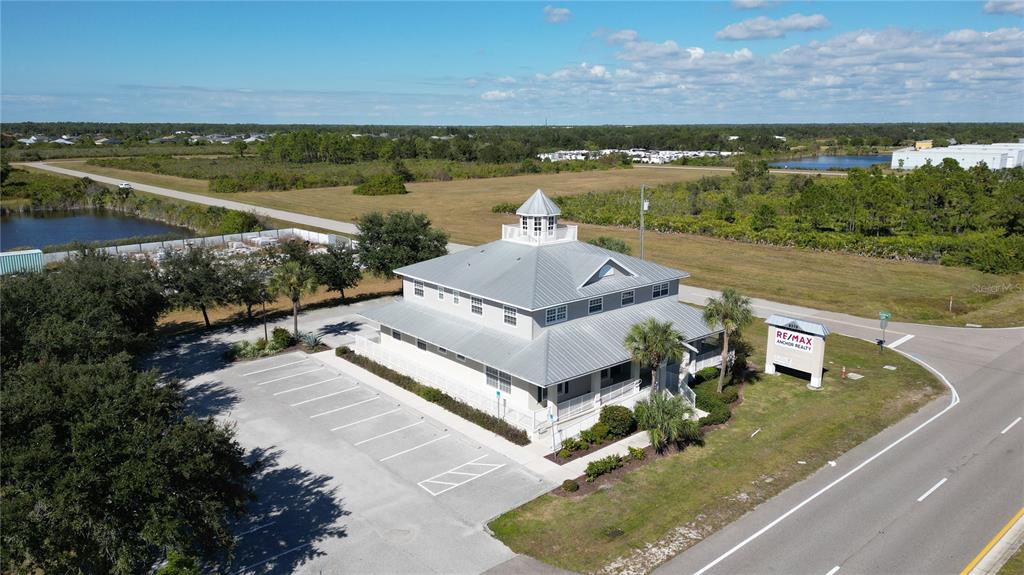 An aerial view shows a two-story building with a metal roof and a cupola — 8379 GASPARILLA ROAD, ROTONDA WEST, FL