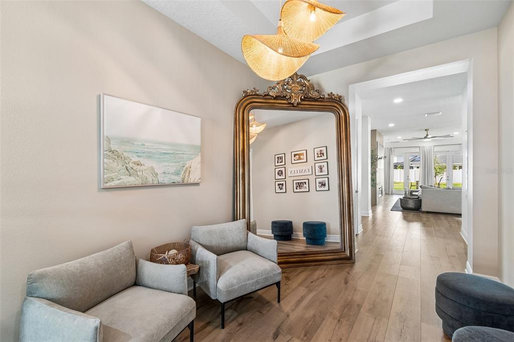 An entryway features two gray armchairs, a large ornate gold mirror, and woven pendant lights — 6107 NIKKI LANE LANE, ODESSA, FL