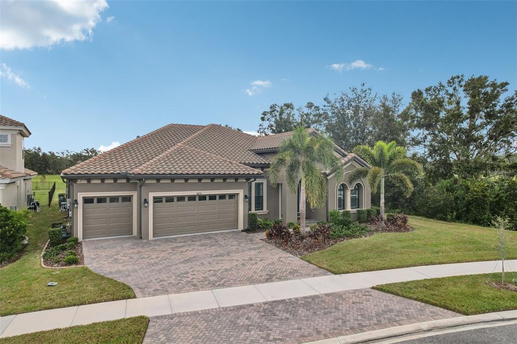A single-story house with a tile roof, two-car garage, and a paved driveway — 14235 SWISS BRIDGE DRIVE, RIVERVIEW, FL