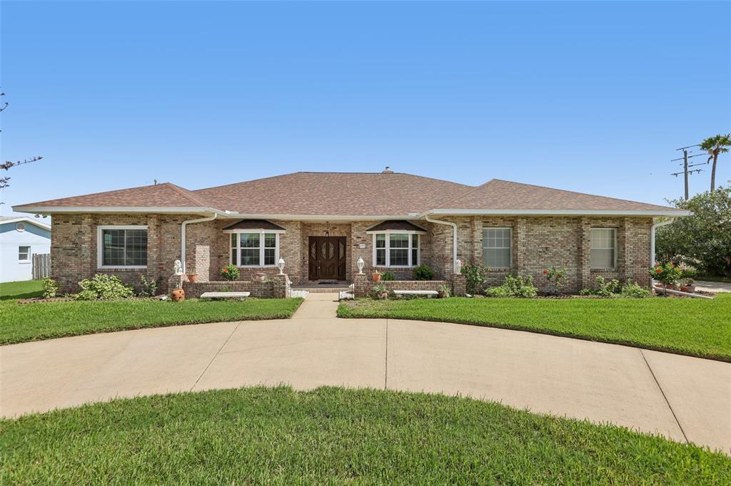 A single-story brick house with a hip roof and a curved concrete driveway — 235 ANN RUSTIN DRIVE, ORMOND BEACH, FL