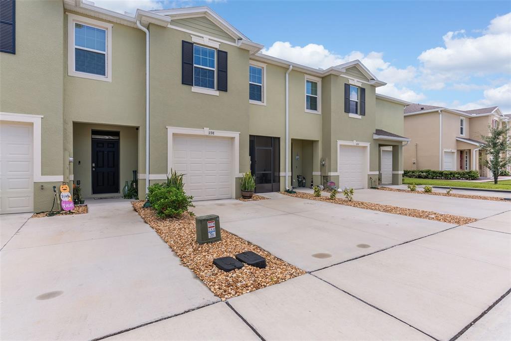 A row of two-story townhomes with light green stucco exteriors and concrete driveways — 1198 LIDO DRIVE, HOWEY IN THE HILLS, FL
