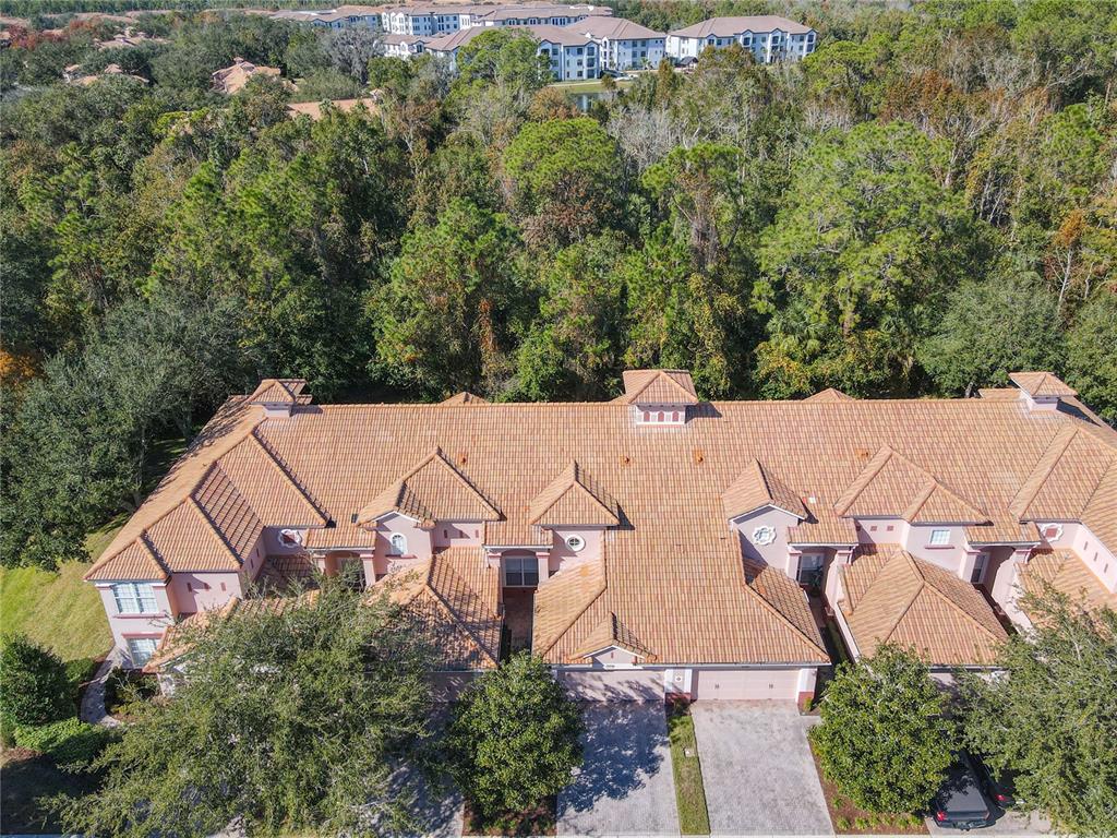 An aerial view shows the tiled roof and exterior of a multi-unit residential building — 1300 GILFORD POINT LANE, DAVENPORT, FL