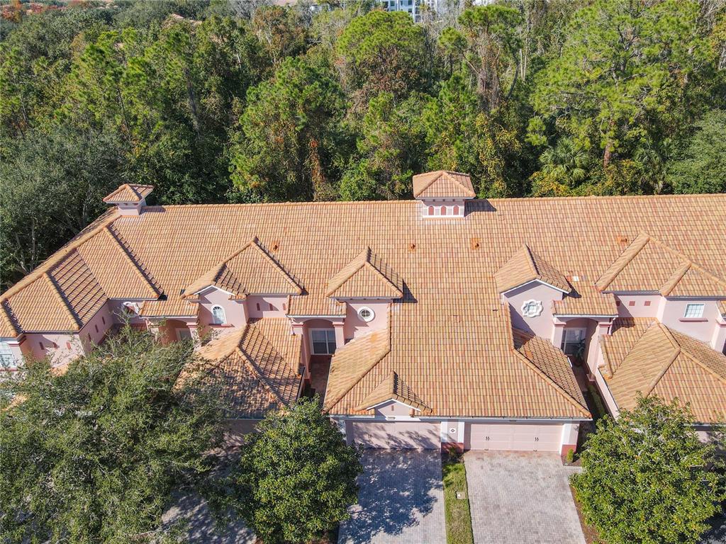 An aerial view shows the tiled roof and front entrances of a multi-unit residential building — 1300 GILFORD POINT LANE, DAVENPORT, FL