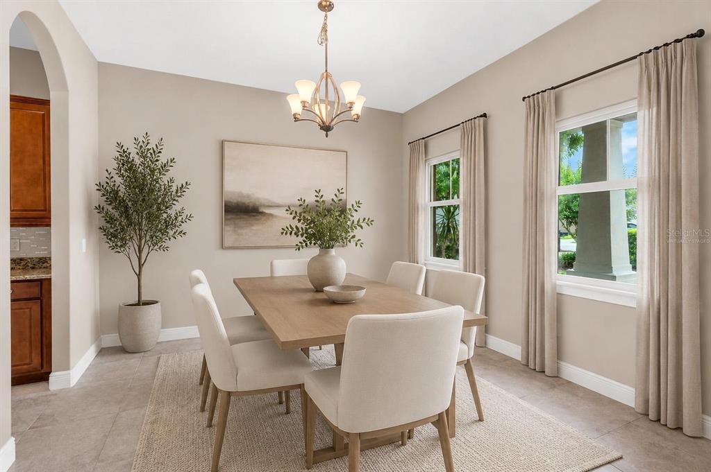 A dining room with a wooden table, six chairs, a chandelier, and two windows — 903 VICTORIA HILLS DRIVE S, DELAND, FL