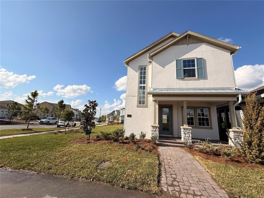 A two-story house with a white stucco exterior and a stone-accented front porch — 10374 PEARSON AVE, ORLANDO, FL