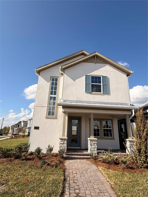 A two-story house with a white stucco exterior, stone accents, and a brick walkway — 10374 PEARSON AVE, ORLANDO, FL