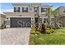A two-story house with a paved driveway, a two-car garage, and a landscaped front yard — 32588 TREE OF LIFE AVENUE, WESLEY CHAPEL, FL