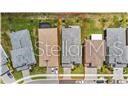 An aerial view shows a row of suburban houses with driveways and backyards — 32588 TREE OF LIFE AVENUE, WESLEY CHAPEL, FL
