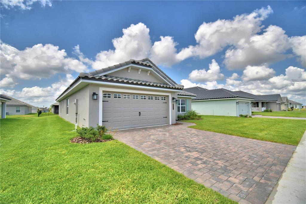 A single-story house with a paved driveway, a two-car garage, and a tiled roof — 4651 GRANDVIEW GLEN DRIVE, AUBURNDALE, FL