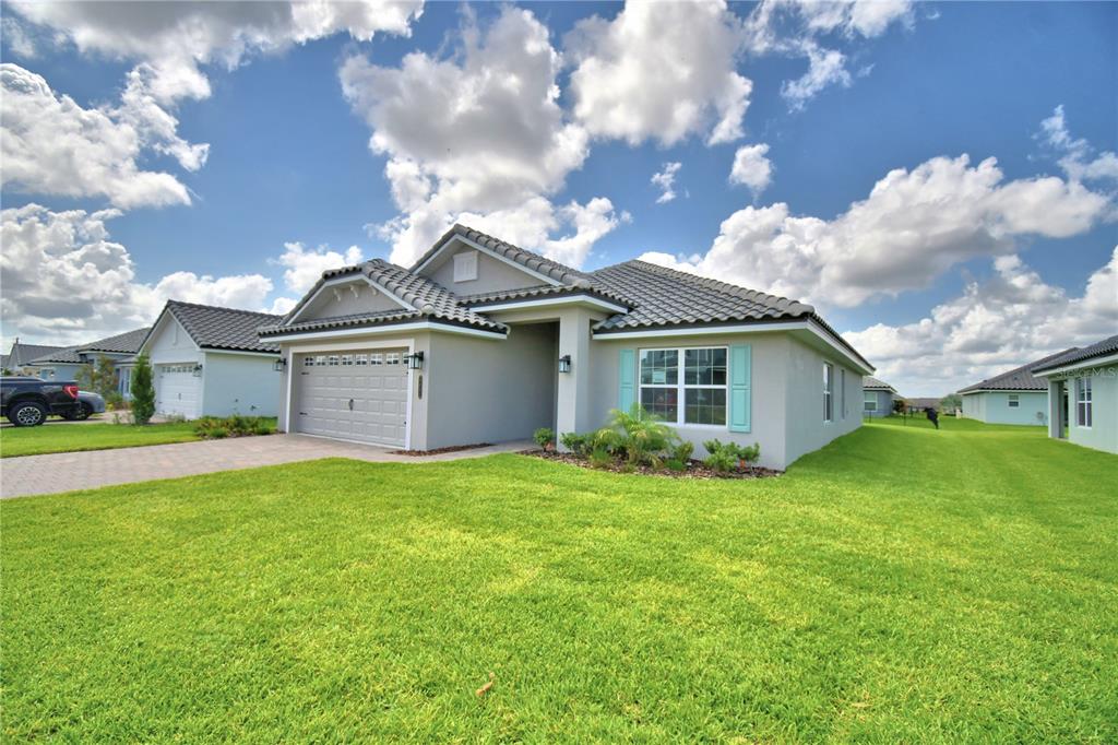 A single-story house with a gray stucco exterior, tile roof, and a two-car garage — 4651 GRANDVIEW GLEN DRIVE, AUBURNDALE, FL