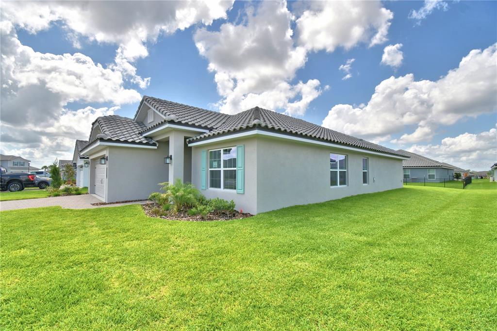 A single-story house with a gray stucco exterior, tile roof, and light blue window shutters — 4651 GRANDVIEW GLEN DRIVE, AUBURNDALE, FL