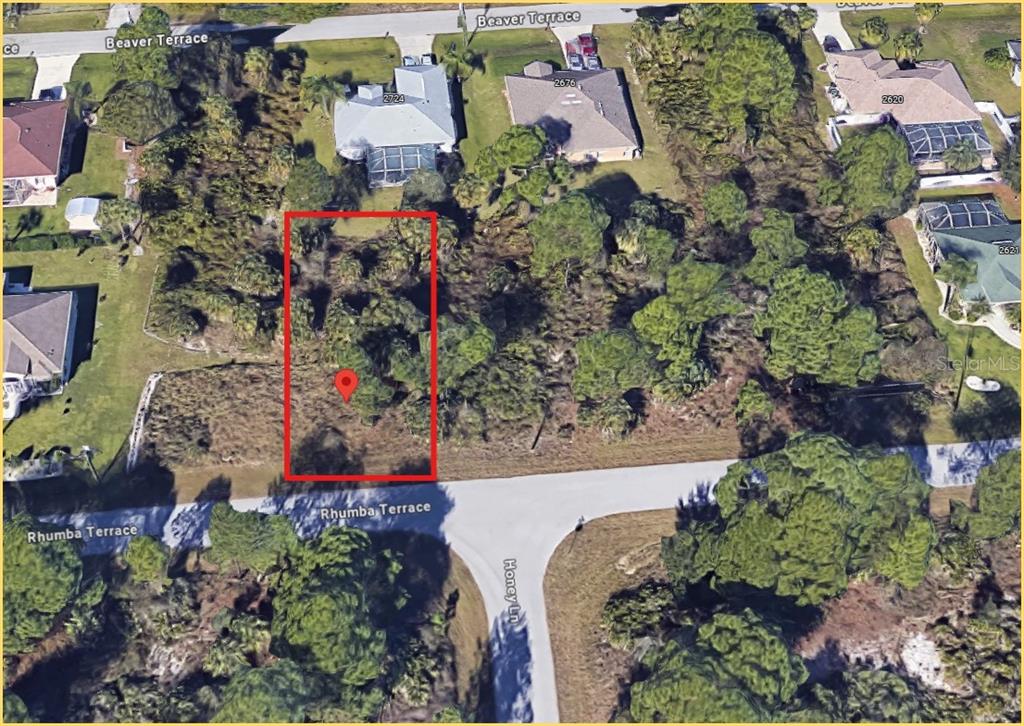 An aerial view shows a vacant, wooded residential lot outlined in red on a corner street — RHUMBA TERRACE Lot 29, NORTH PORT, FL