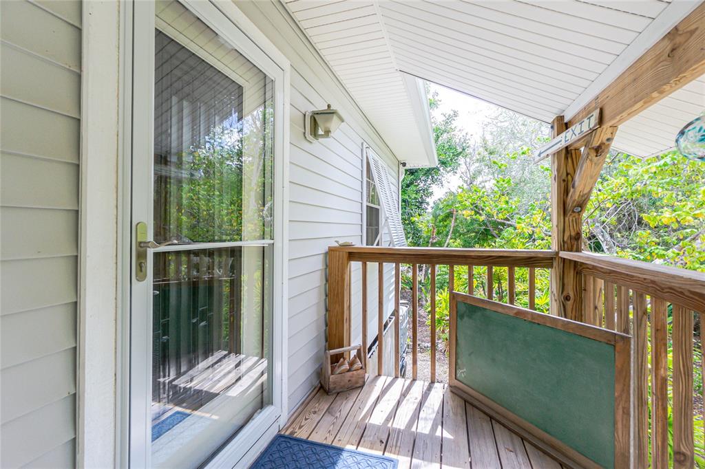 A wooden deck features a storm door, a chalkboard, and a wooden shoe crate — 700 YALE STREET, ENGLEWOOD, FL