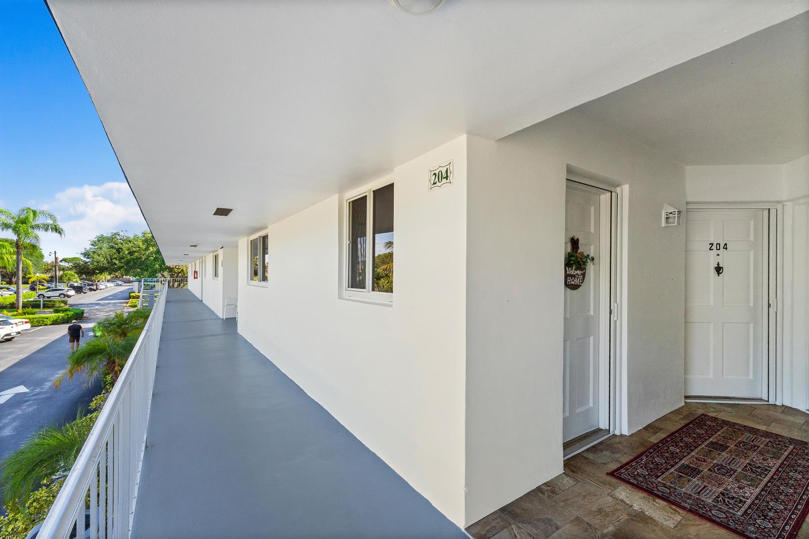 An exterior walkway leads to the entrance of a residential unit marked with number 204 — 4 Westwood Avenue # 204, Jupiter FL 33469, JUPITER, FL